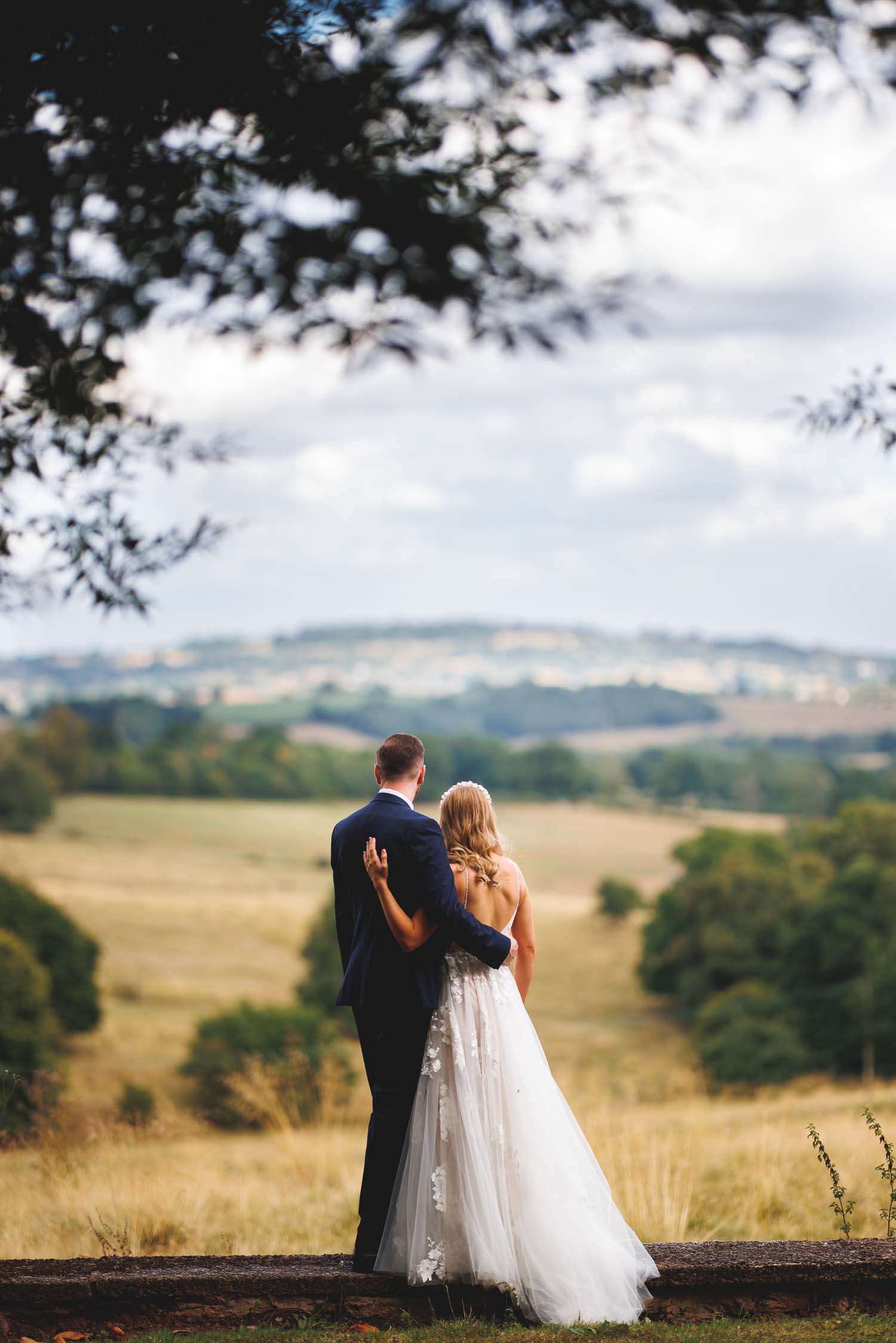 The Bride and groom hug while they enjoy the view at Bredenbury Court Barns in Herefordshire.